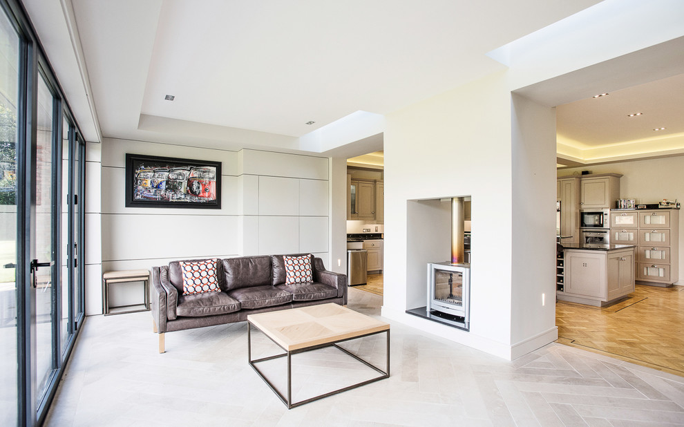 Пример оригинального дизайна: открытая гостиная комната среднего размера в современном стиле с белыми стенами, полом из керамогранита, двусторонним камином и фасадом камина из штукатурки без телевизора