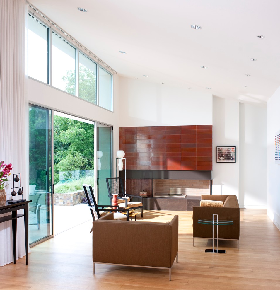 Immagine di un soggiorno design aperto con pareti bianche e parquet chiaro