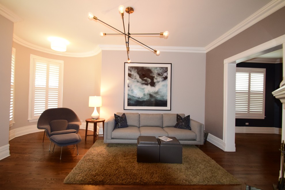 Cette image montre un grand salon minimaliste fermé avec un mur gris et parquet foncé.