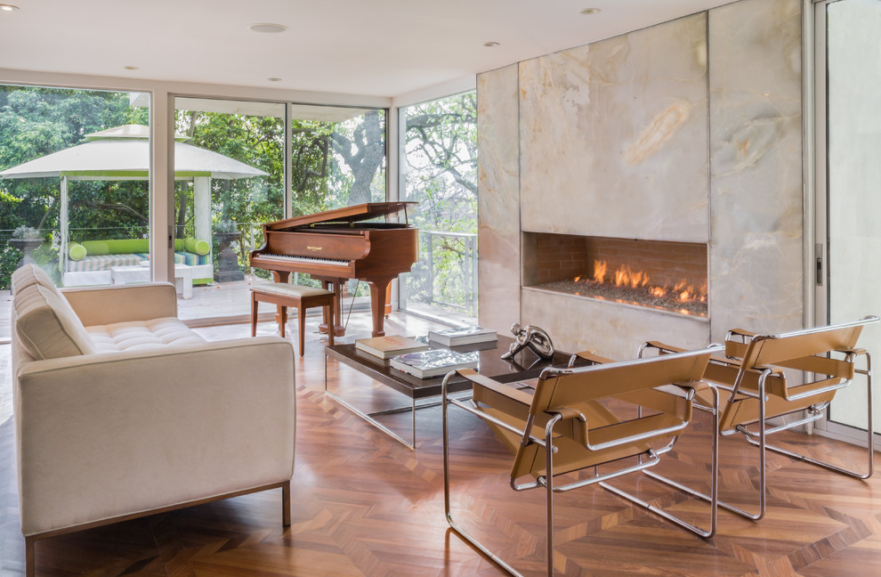 Großes, Repräsentatives Modernes Wohnzimmer mit braunem Holzboden, Gaskamin und Kaminumrandung aus Stein in Los Angeles