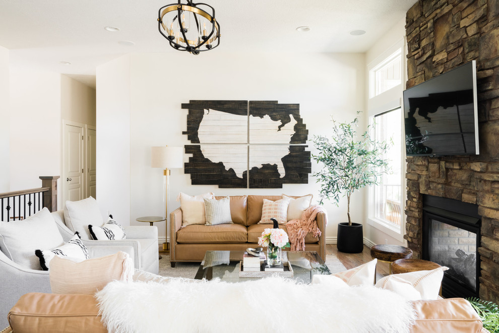 Offenes Country Wohnzimmer mit weißer Wandfarbe, braunem Holzboden, Tunnelkamin, Kaminumrandung aus Stein, TV-Wand und braunem Boden in Salt Lake City