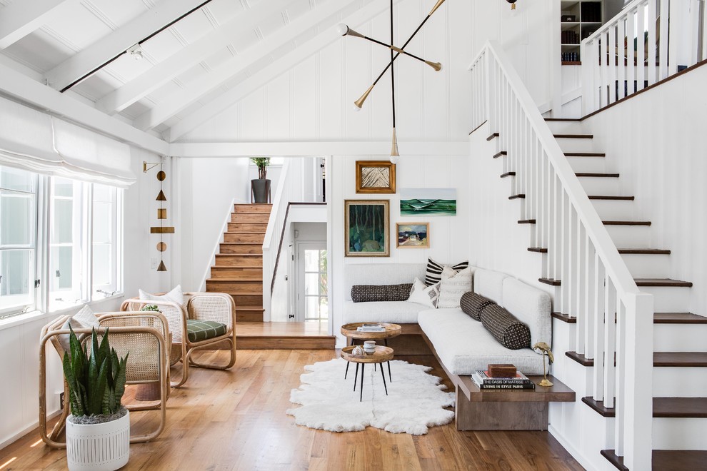 Skandinavisches Wohnzimmer mit weißer Wandfarbe, braunem Holzboden und braunem Boden in Orange County