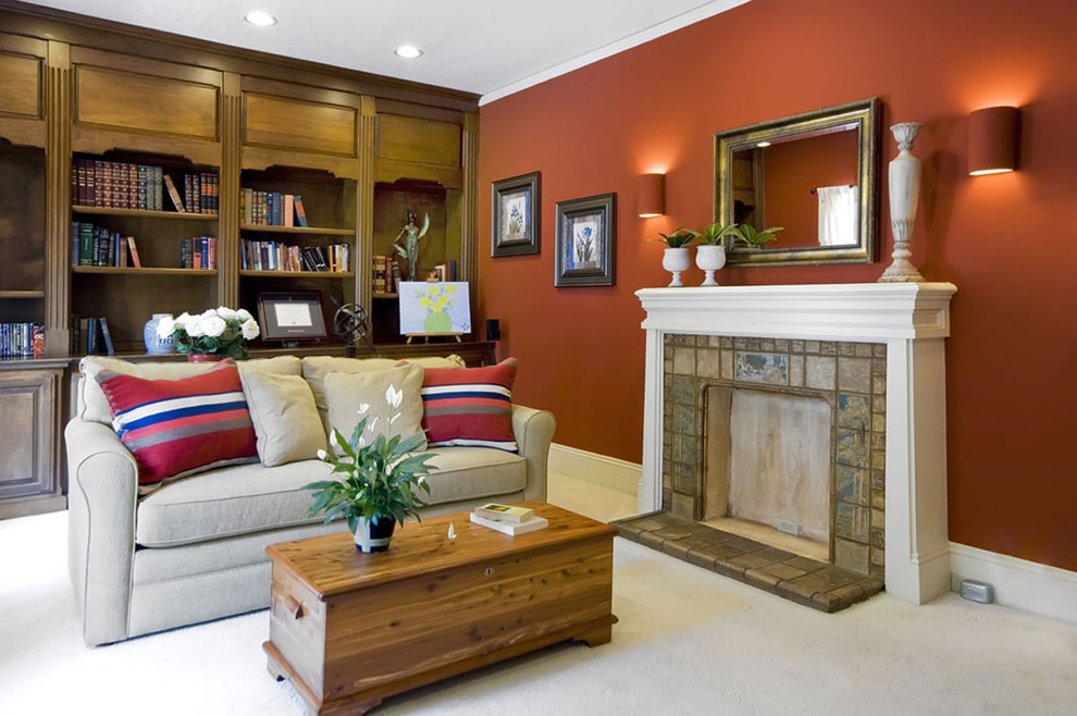 Источник вдохновения для домашнего уюта: гостиная комната в классическом стиле с красными стенами, стандартным камином и фасадом камина из плитки