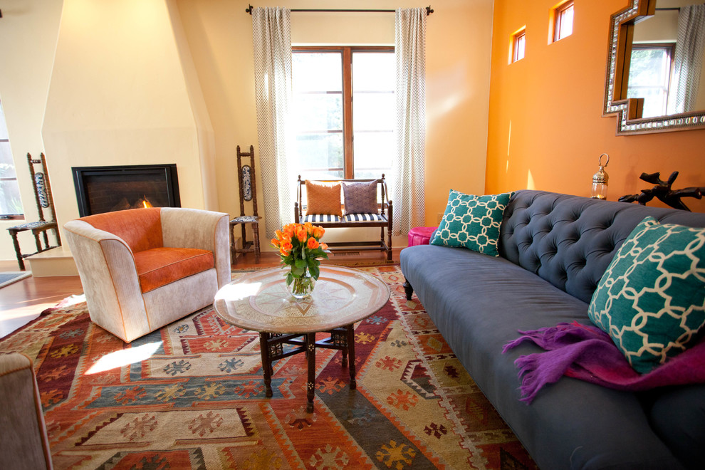 Свежая идея для дизайна: гостиная комната в средиземноморском стиле с оранжевыми стенами и стандартным камином - отличное фото интерьера