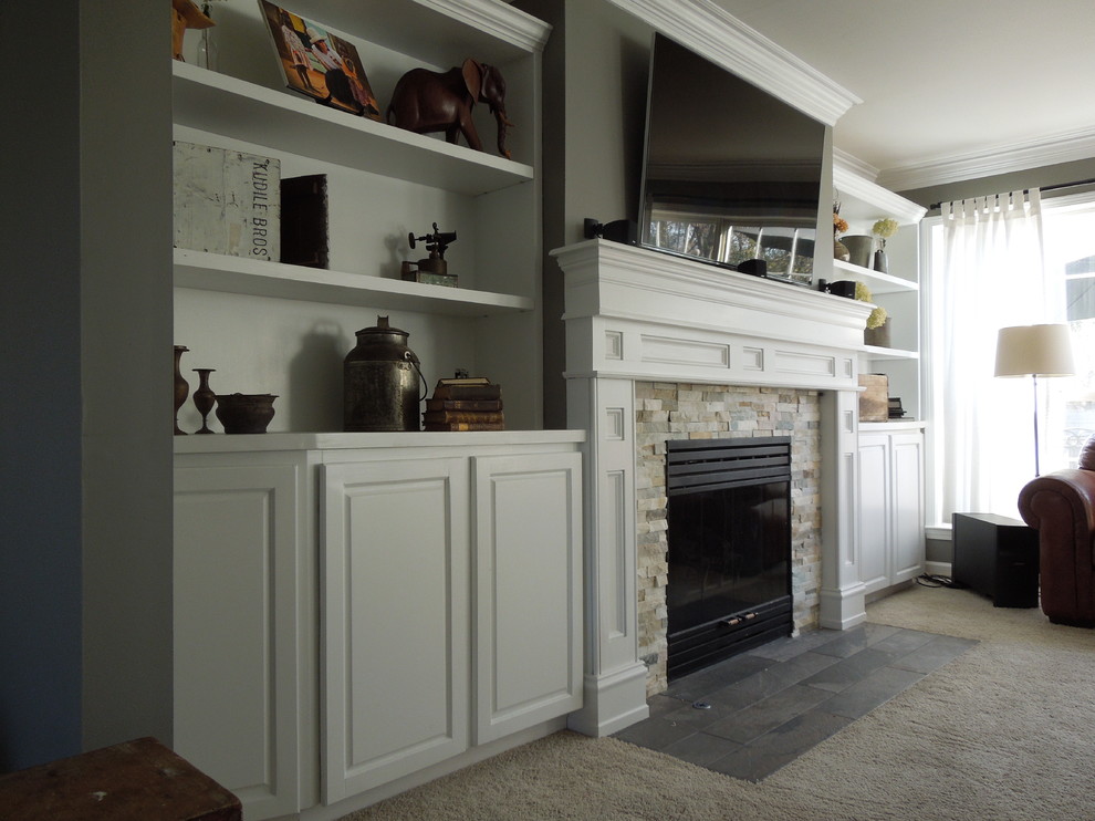 Aménagement d'un salon classique de taille moyenne avec un mur gris, moquette, une cheminée standard, un manteau de cheminée en pierre, un téléviseur fixé au mur et un sol beige.