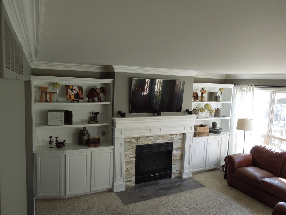 Exemple d'un salon chic de taille moyenne avec un mur gris, moquette, une cheminée standard, un manteau de cheminée en pierre, un téléviseur fixé au mur et un sol beige.