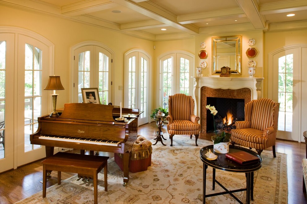 Idéer för mellanstora amerikanska separata vardagsrum, med ett musikrum, beige väggar, mellanmörkt trägolv, en standard öppen spis, en spiselkrans i trä och brunt golv