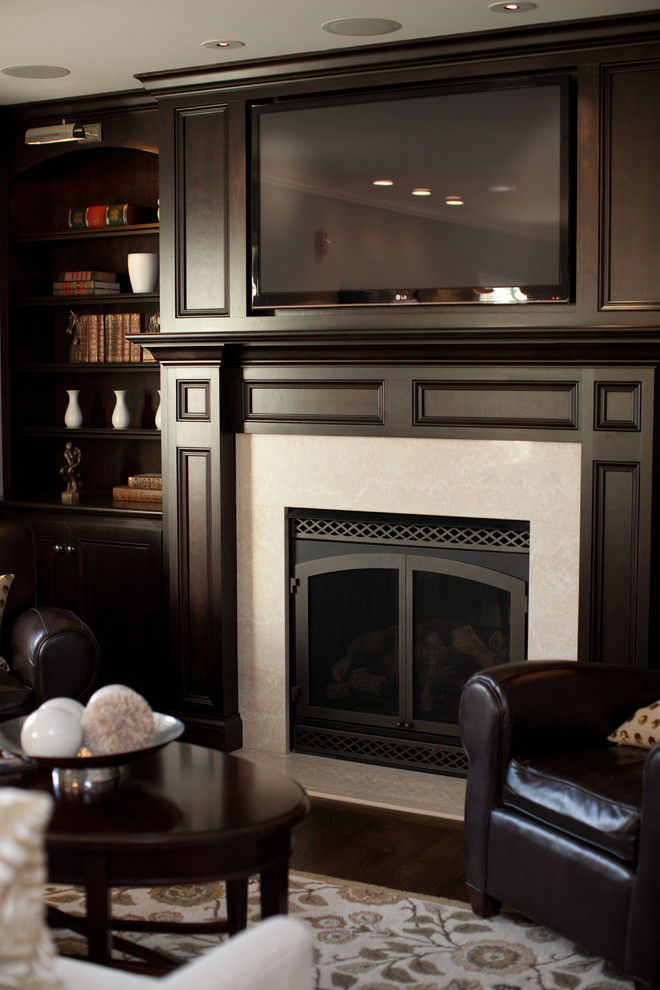 Cette image montre un salon traditionnel de taille moyenne et fermé avec une salle de réception, un mur beige, parquet foncé, une cheminée standard, un manteau de cheminée en carrelage et un téléviseur encastré.
