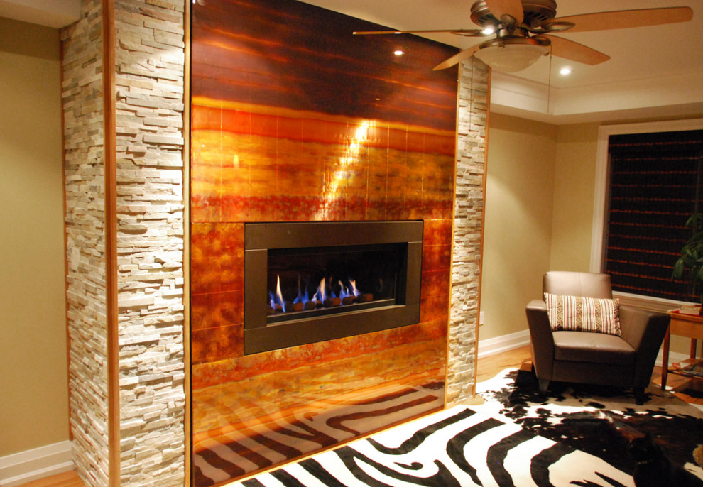 Inspiration for a large modern formal enclosed living room in Toronto with beige walls, light hardwood flooring, a metal fireplace surround and a corner tv.