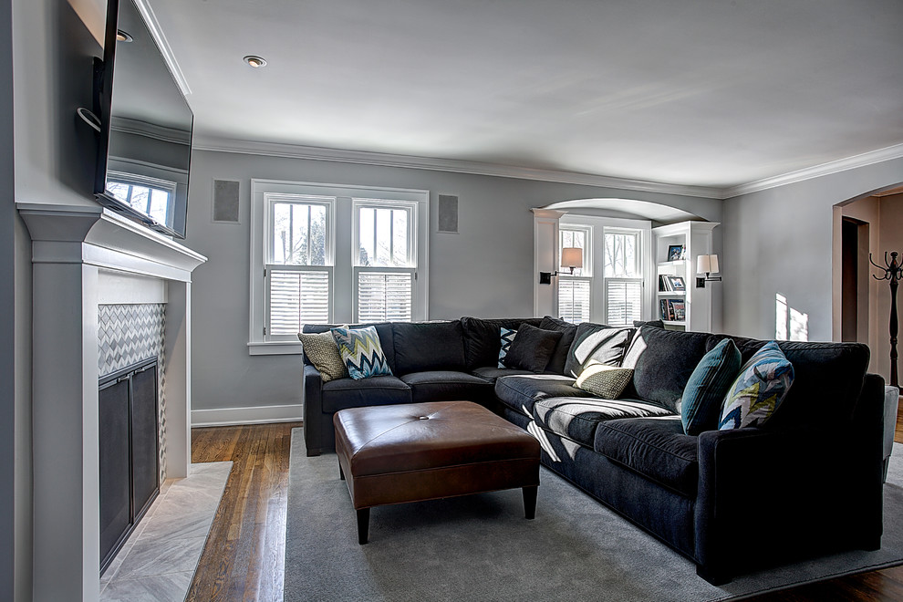 Mittelgroßes, Abgetrenntes Rustikales Wohnzimmer mit grauer Wandfarbe, hellem Holzboden und TV-Wand in Grand Rapids