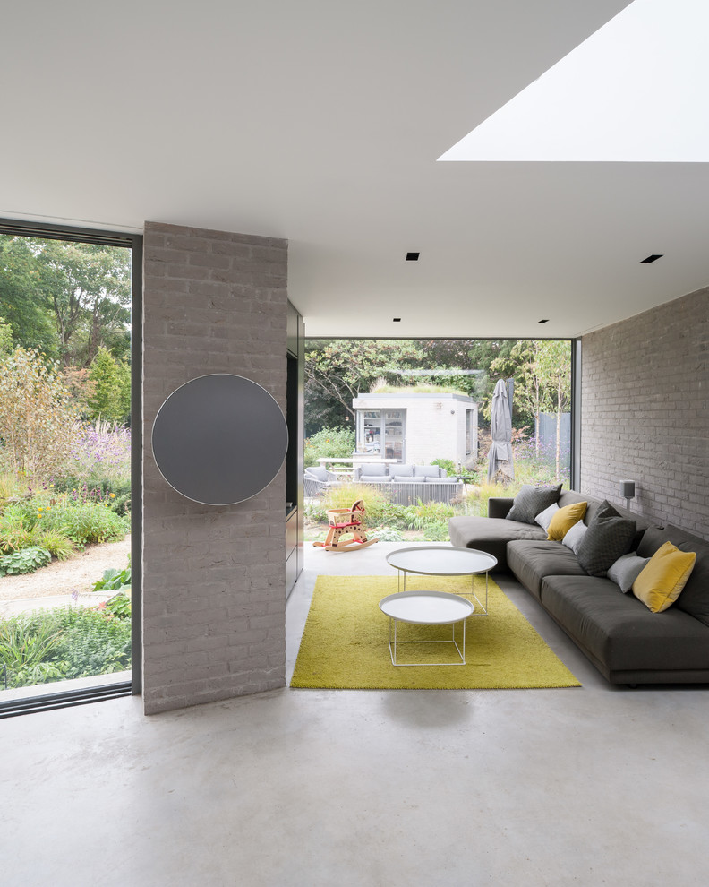 Contemporary enclosed living room in Surrey with brown walls, travertine flooring and white floors.