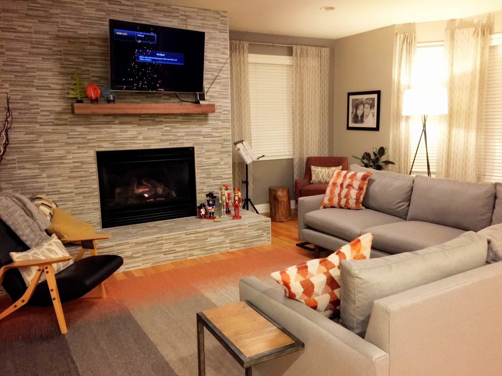 Kleines, Offenes Retro Wohnzimmer mit grauer Wandfarbe, braunem Holzboden, Eckkamin, gefliester Kaminumrandung und TV-Wand in Denver