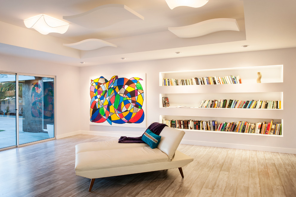 Стильный дизайн: большая открытая гостиная комната в современном стиле с с книжными шкафами и полками, белыми стенами и полом из ламината - последний тренд
