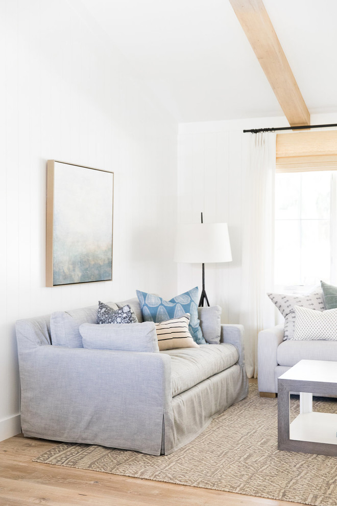 Idee per un soggiorno stile marino di medie dimensioni e aperto con pareti bianche, parquet chiaro e camino bifacciale