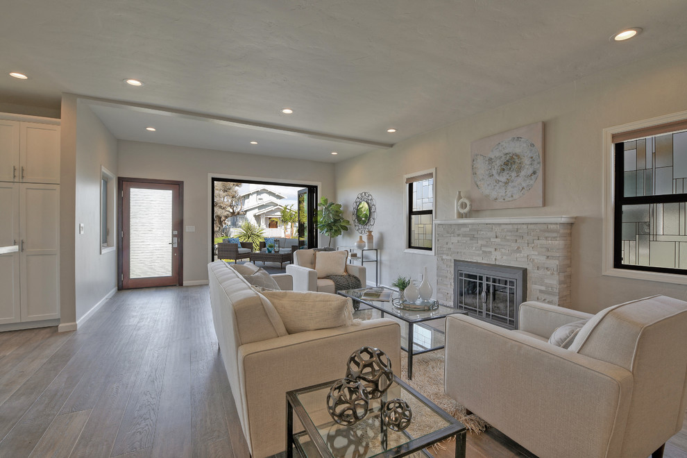 Photo of a large contemporary open plan living room in San Diego with a music area, grey walls, light hardwood flooring, a standard fireplace, a stone fireplace surround, a built-in media unit and grey floors.