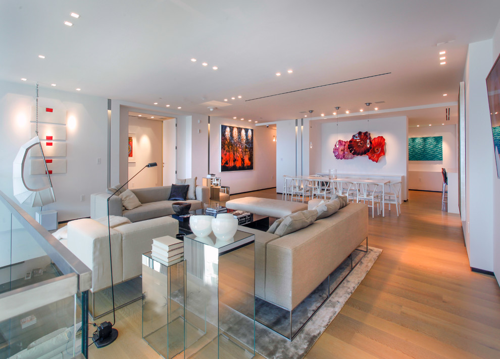 Photo of a modern living room in Miami with white walls and light hardwood flooring.