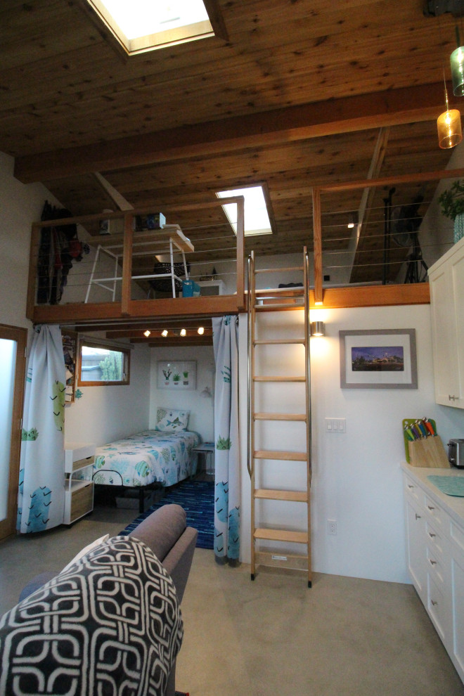 Kleines, Offenes Mediterranes Wohnzimmer ohne Kamin mit weißer Wandfarbe, Betonboden, TV-Wand und grauem Boden in San Diego