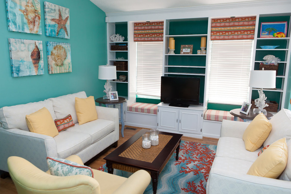 Example of a mid-sized island style medium tone wood floor and brown floor living room design in DC Metro with blue walls, a tv stand and no fireplace