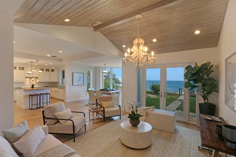 Immagine di un soggiorno stile marinaro aperto con pareti bianche, pavimento in legno massello medio e pavimento beige