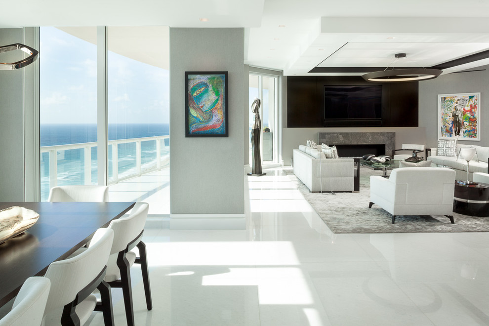 Großes, Offenes, Repräsentatives Modernes Wohnzimmer mit Marmorboden, verstecktem TV, weißem Boden, grauer Wandfarbe, Kamin und Kaminumrandung aus Stein in Miami
