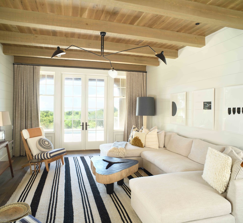 Design ideas for a coastal living room in Charleston with white walls and dark hardwood flooring.