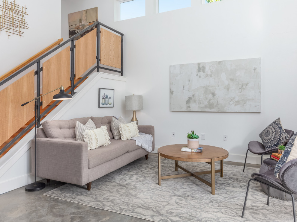 Offenes Modernes Wohnzimmer mit weißer Wandfarbe, Betonboden und grauem Boden in Austin