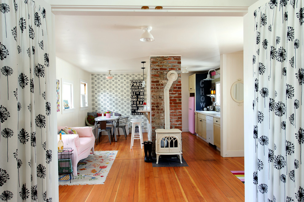 Foto de salón abierto ecléctico con suelo de madera en tonos medios y estufa de leña