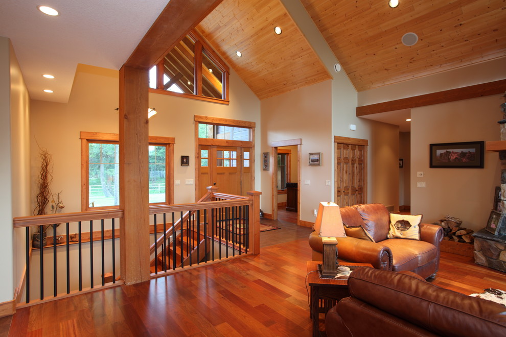 Foto di un soggiorno american style aperto con pareti beige, pavimento in legno massello medio, stufa a legna e cornice del camino in pietra