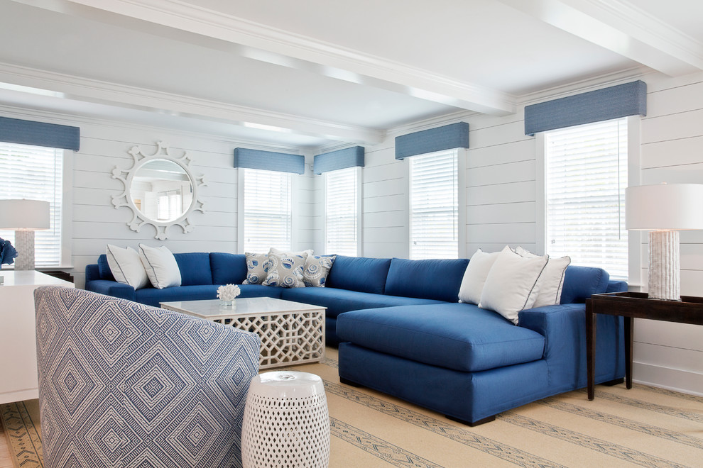 This is an example of a large nautical living room in Boston with white walls and no tv.