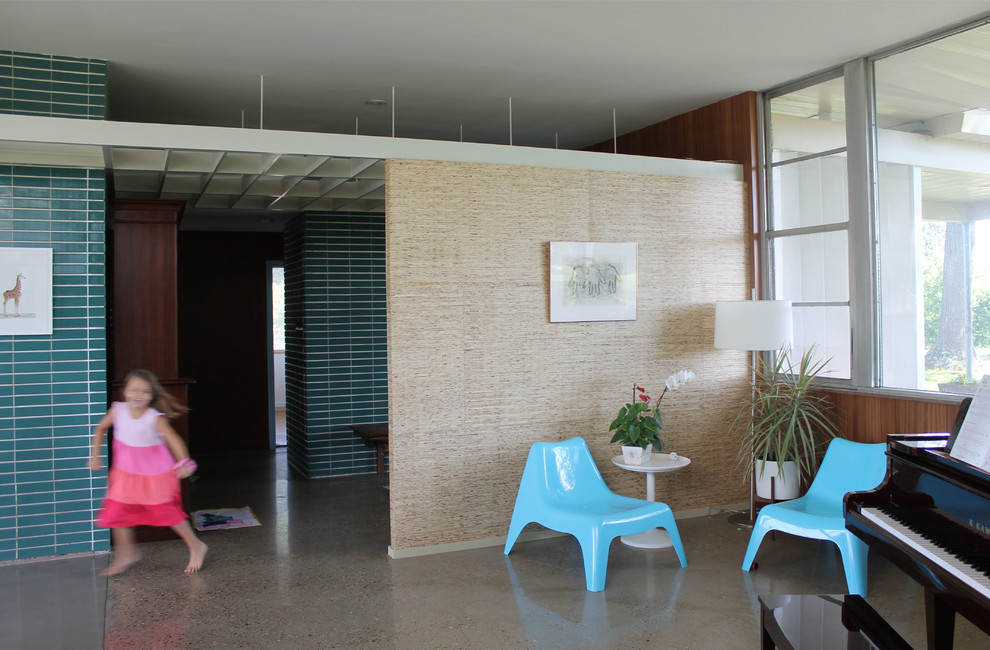 Foto di un soggiorno moderno di medie dimensioni con pavimento in cemento, camino classico e cornice del camino piastrellata