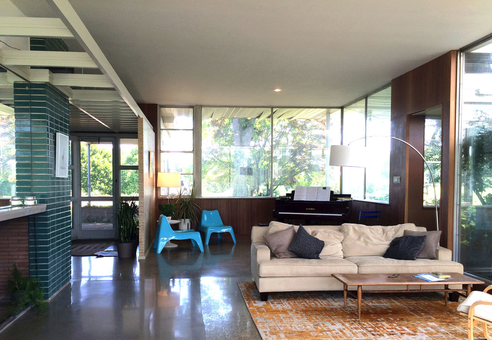 Photo of a medium sized midcentury living room in San Luis Obispo with concrete flooring, a standard fireplace and a tiled fireplace surround.