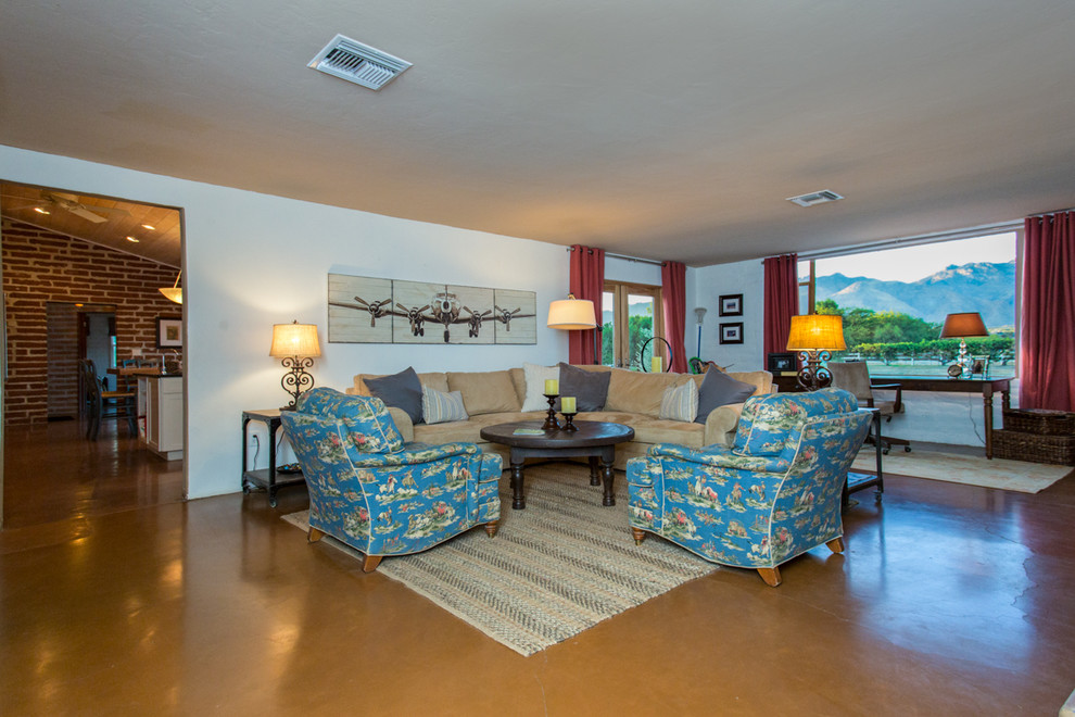 フェニックスにある低価格の中くらいなサンタフェスタイルのおしゃれなリビング (白い壁、コンクリートの床、標準型暖炉、テレビなし) の写真