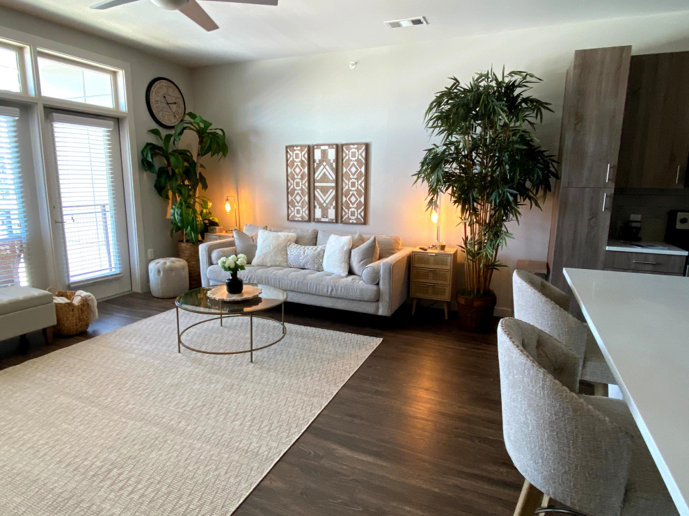 Diseño de salón abierto retro con paredes beige, suelo vinílico, televisor independiente y suelo marrón