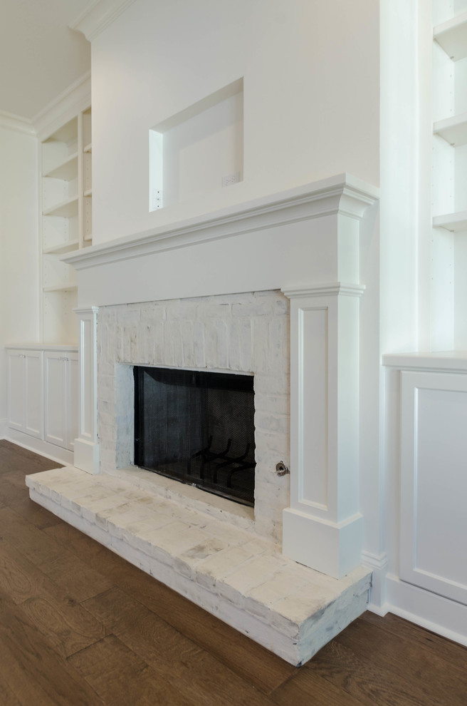 ニューオリンズにある高級な広いトラディショナルスタイルのおしゃれなLDK (白い壁、無垢フローリング、標準型暖炉、レンガの暖炉まわり、テレビなし) の写真