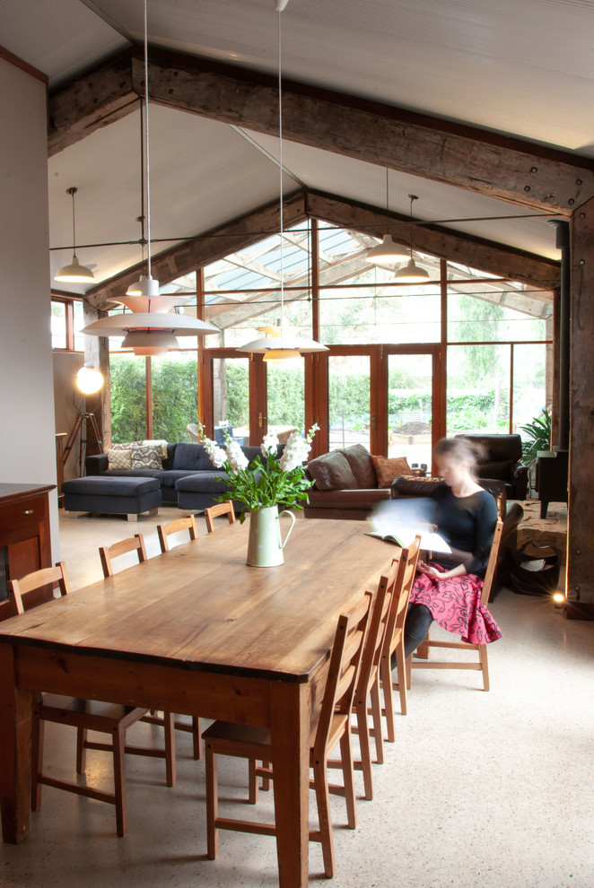 Immagine di una grande sala da pranzo stile rurale con pareti beige, pavimento in cemento e pavimento beige