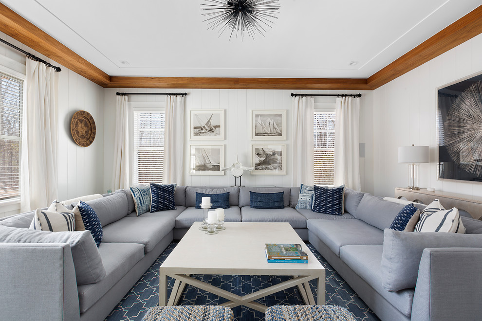 Example of a mid-sized beach style enclosed dark wood floor and brown floor living room design in New York with white walls and a media wall
