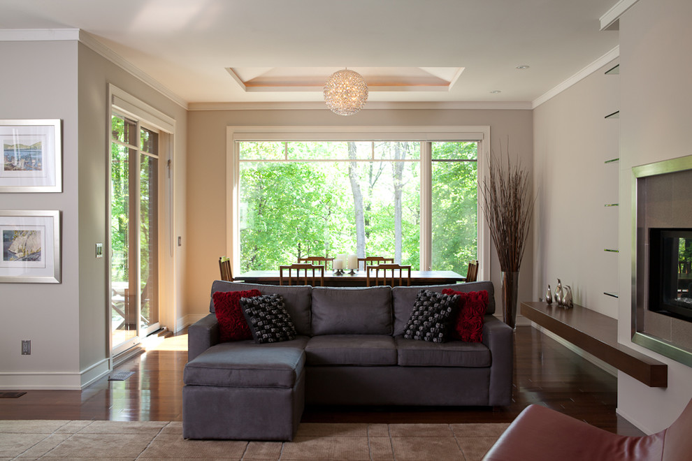 Großes, Repräsentatives, Fernseherloses, Offenes Modernes Wohnzimmer mit beiger Wandfarbe, dunklem Holzboden, Gaskamin und Kaminumrandung aus Stein in Toronto