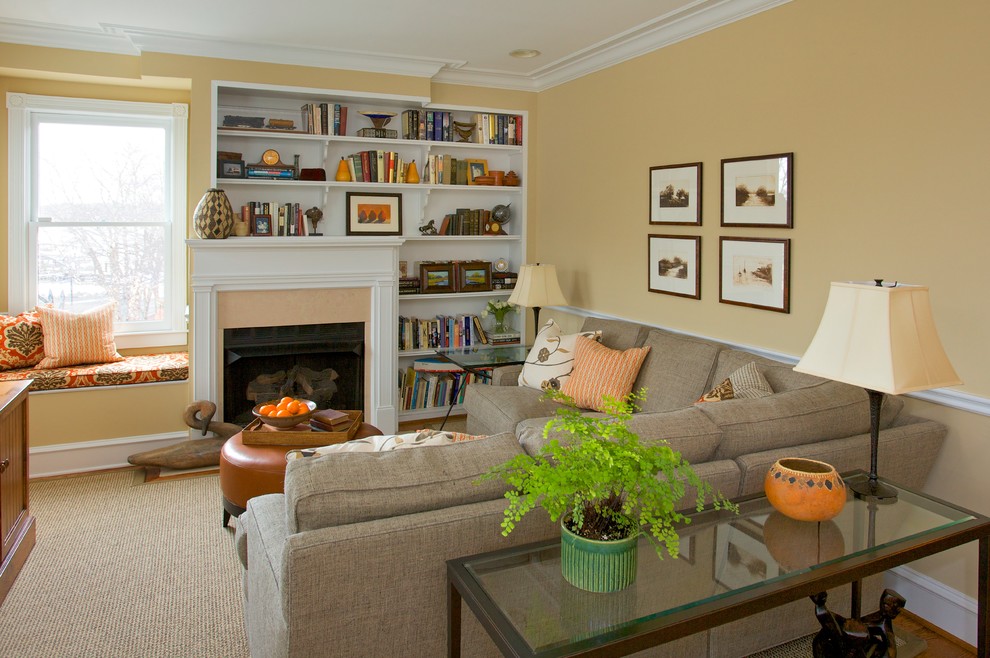 Exemple d'un salon chic de taille moyenne et ouvert avec une bibliothèque ou un coin lecture, un mur beige, moquette, une cheminée standard, un manteau de cheminée en plâtre et aucun téléviseur.