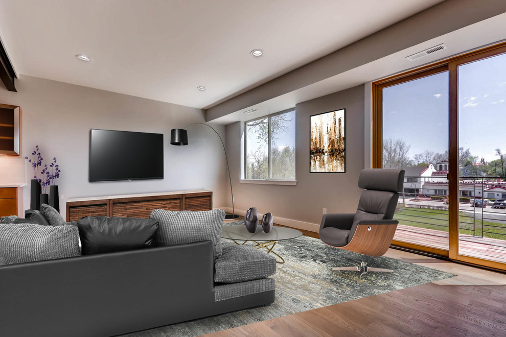 Esempio di un ampio soggiorno industriale aperto con sala formale, pareti grigie, parquet scuro e TV a parete