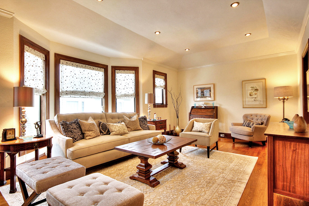 Cette image montre un grand salon traditionnel ouvert avec un mur beige, parquet clair, une cheminée standard et un manteau de cheminée en plâtre.