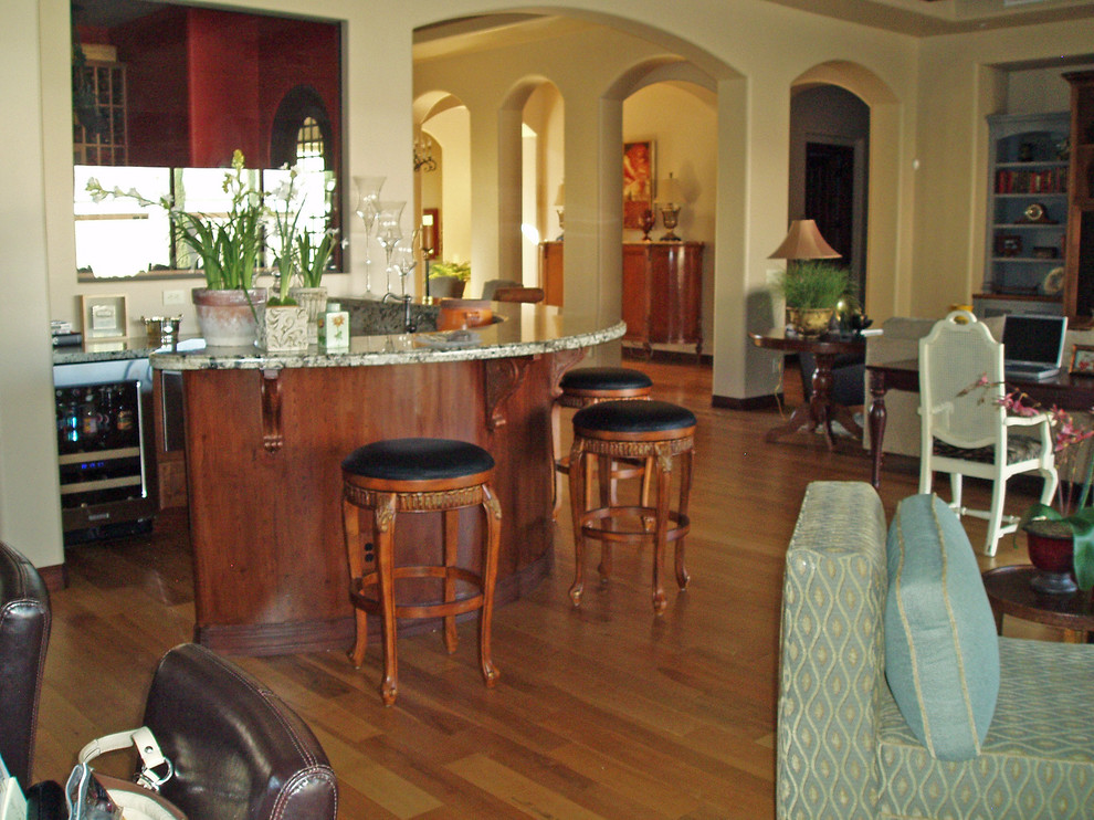 This is an example of a large traditional open plan living room in Phoenix with a home bar, yellow walls and light hardwood flooring.