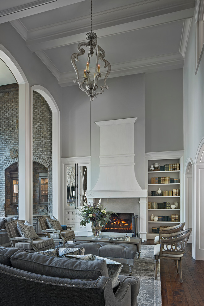 На фото: парадная, изолированная гостиная комната в классическом стиле с серыми стенами, темным паркетным полом, стандартным камином и коричневым полом без телевизора