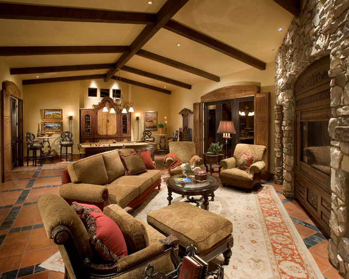 This is an example of an expansive mediterranean formal open plan living room in Phoenix with beige walls, brick flooring, a standard fireplace, a stone fireplace surround, a built-in media unit and red floors.