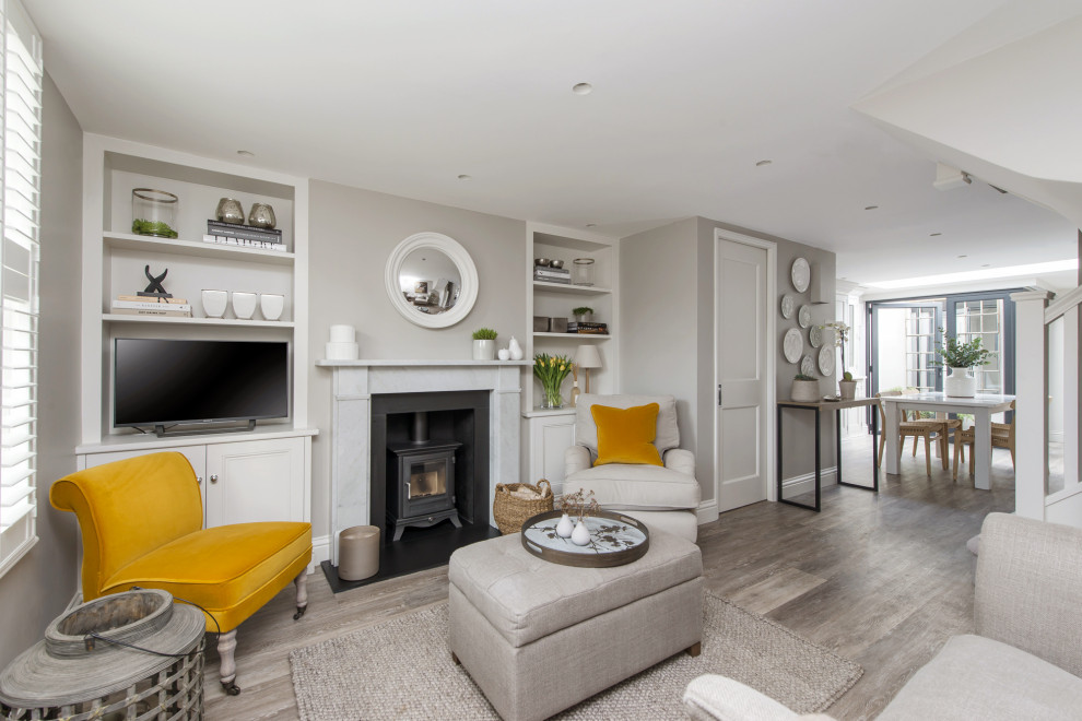 Design ideas for a large classic open plan living room in London with grey walls, a wood burning stove, a metal fireplace surround, a freestanding tv and grey floors.