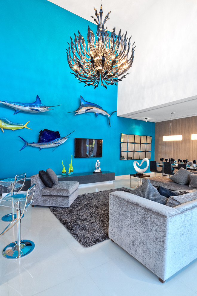 Idee per un soggiorno tropicale aperto con pareti blu e TV a parete