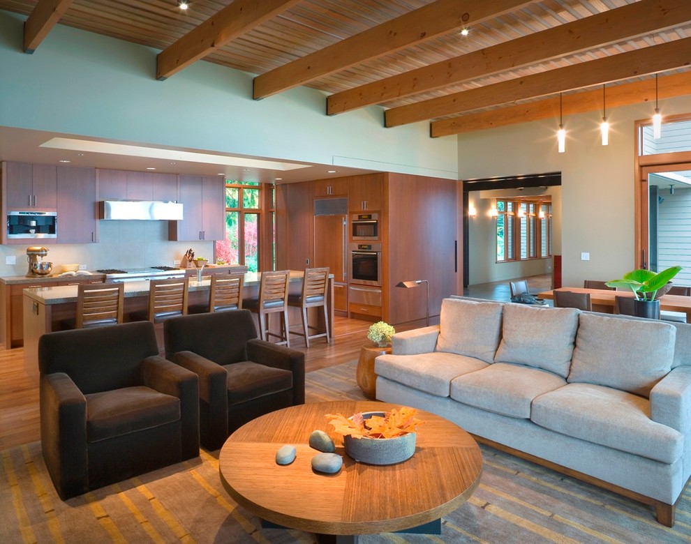 Großes, Offenes Modernes Wohnzimmer mit braunem Holzboden, Kamin und Kaminumrandung aus Beton in Seattle