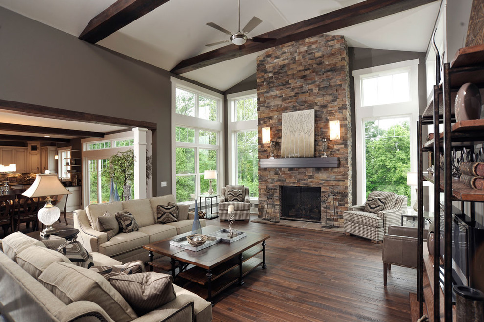 Inspiration for a contemporary open concept dark wood floor and exposed beam living room remodel in Columbus with gray walls, a standard fireplace, a stacked stone fireplace and no tv