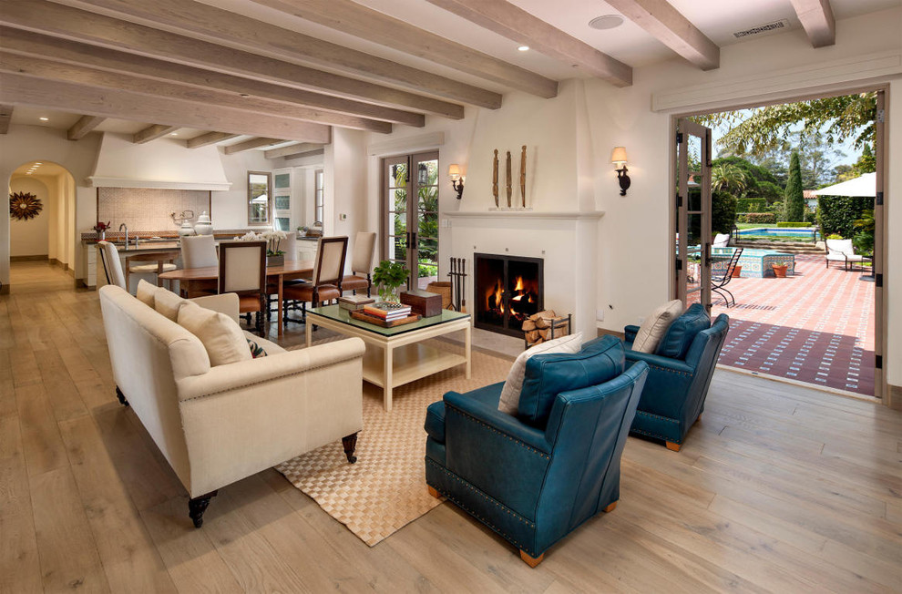 Repräsentatives, Fernseherloses, Offenes Mediterranes Wohnzimmer mit beiger Wandfarbe, hellem Holzboden und Kamin in Santa Barbara