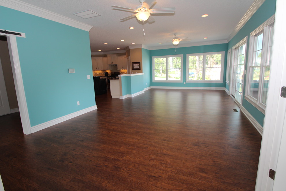 Immagine di un soggiorno stile marinaro aperto con pareti blu, pavimento in legno massello medio e TV nascosta