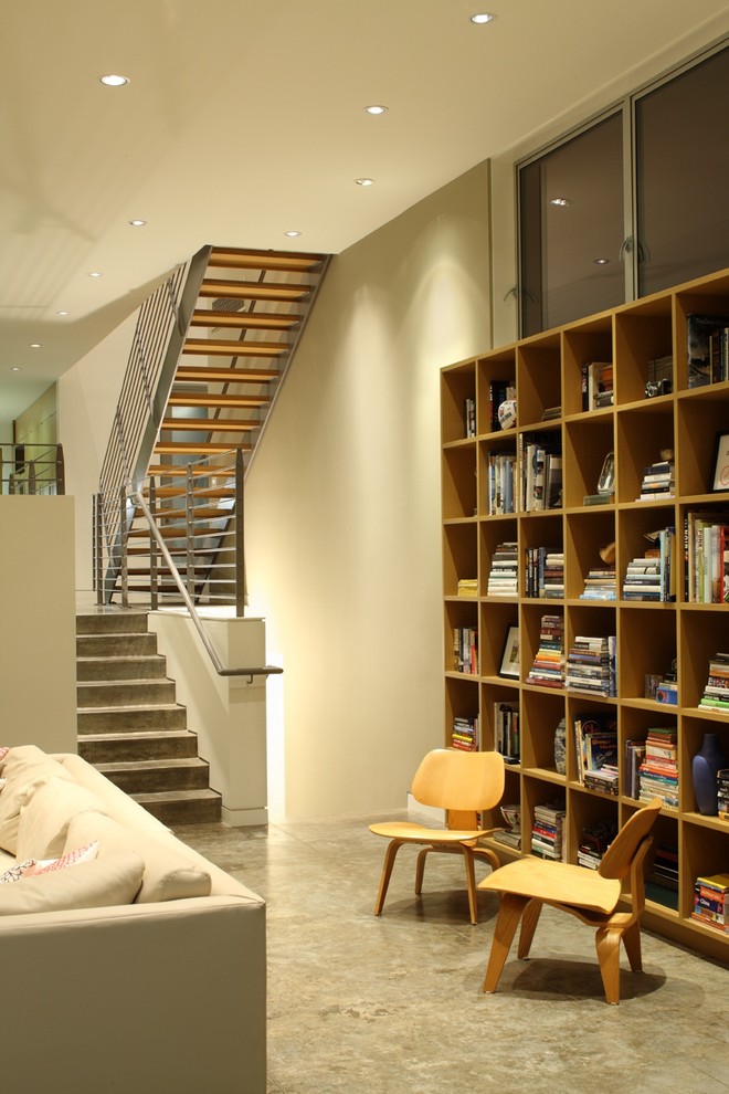 Exemple d'un salon tendance avec une bibliothèque ou un coin lecture et un mur beige.